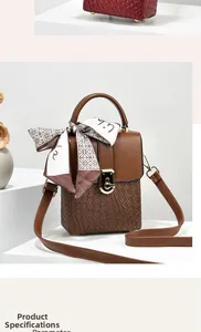 Dettaglio borsa in pelle marrone con trama a diamante e foulard in seta sul manico tondo