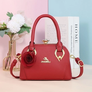 Détail d'un sac à main rouge en similicuir avec fleur 3D et logo chat doré