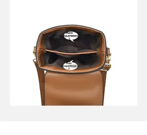 Internal view of brown mini bag showing two main storage compartments and gold hardware