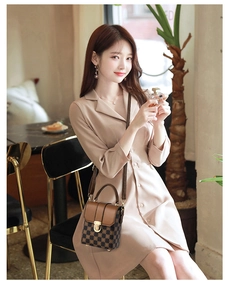 Detailed view of a brown checkered mini crossbody bag with gold metal snap closure
