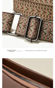 Detail of bohemian geometric woven strap with dark grey adjustable metal buckle on brown bag