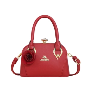 Sac à main élégant en cuir PU rouge avec détails dorés et charm rose sur fond blanc