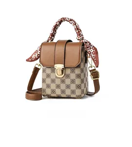 Detail of checkered mini square bag with brown leather flap and silk scarf handle