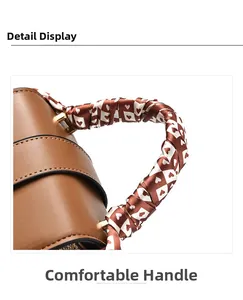 Detail of brown leather mini bag featuring a scarf-wrapped handle with heart patterns