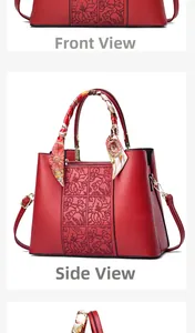Dettaglio borsa rossa con goffratura floreale, foulard di seta e accenti metallici
