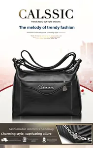 Detail of black embossed leather handbag featuring metal logo and decorative chain