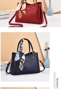 Dettaglio borsa tote in ecopelle con manico in seta decorativo e ciondolo a foglia d'oro