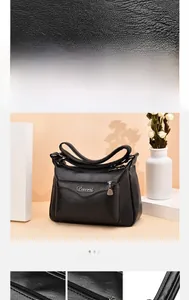 Close-up of black lychee grain leather bag with tassel detail and silver Davni logo