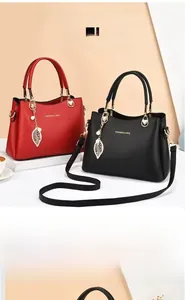Détail du sac à main en cuir à motif litchi avec breloque feuille et bandoulière