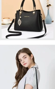 Détails d'un sac à main noir en cuir grainé avec pendentif feuille dorée et bandoulière