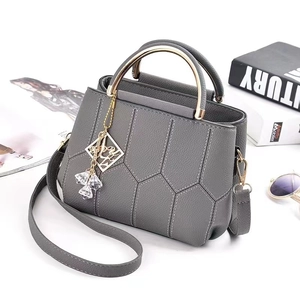 Dark grey lychee textured crossbody bag with metal handle and geometric stitching