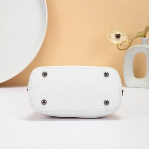 Detailed base view of white lychee leather bag with four protective metal feet