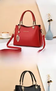 Détails du sac à main rouge et noir en cuir litchi avec pendentif perle et feuille dorée