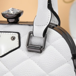 Macro shot of white quilted leather texture with luxury diamond clasp and metal frame