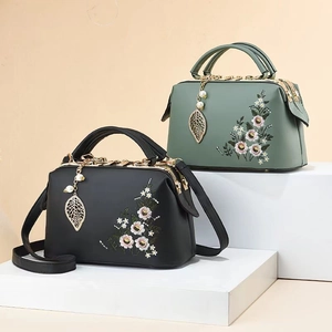 Elegant vintage doctor bag with floral embroidery and leaf pendant in black and green