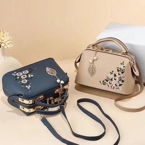 Macro detail of high-quality floral embroidery and gold metal frame on vintage handbags