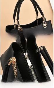 Détails du sac à main noir en cuir grainé avec fermoir coeur doré et chaîne