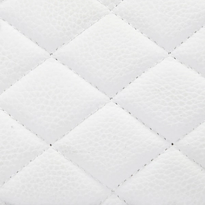 Macro detail of white lychee leather with classic quilted diamond stitching on the handbag