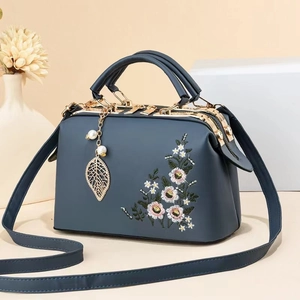 Elegant navy blue handbag with floral embroidery and golden metal leaf charm detail