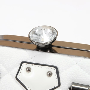 Macro shot of white quilted shell bag showing diamond clasp and silver frame texture