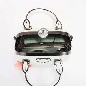 Top view of white pebble leather bag showing interior space and large diamond clasp detail