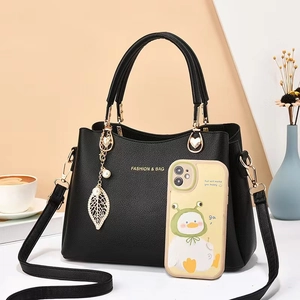 Sac à main élégant en cuir grainé noir avec détails dorés et breloque en perles