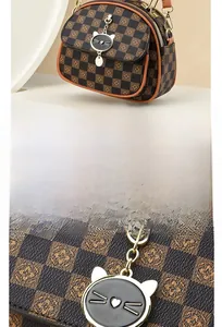 Detailed close-up of the vintage brown checkered pattern and gold zipper hardware
