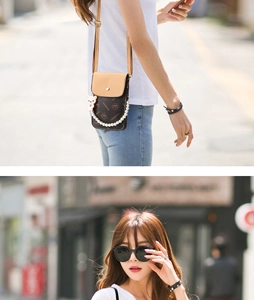 Detail of vintage patterned crossbody bag with elegant pearl chain and bear charm