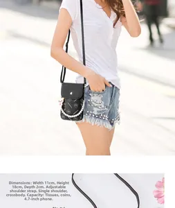 Detail of black lychee grain phone bag with pearl chain and pink bear charm decoration
