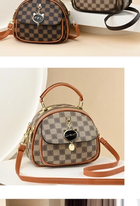 Detail of checkered crossbody bag with cat-shaped hardware and gold double zippers