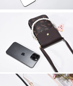Detail view of vintage brown monogram phone bag with pearl handle and pink rabbit charm