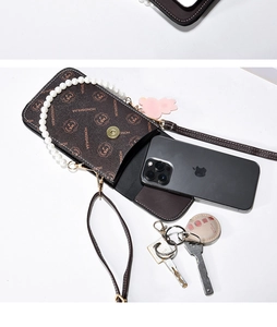 Brown monogram phone bag with pearl handle and long strap showing interior capacity