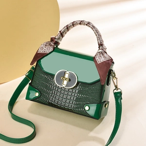 Sac à main vert foncé à motif crocodile avec poignée en foulard et détails dorés brillants