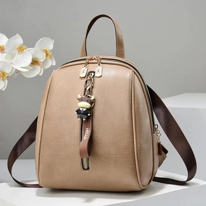 Detail of soft faux leather backpack with vertical zipper and cute cartoon charm