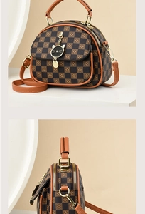 Macro detail of checkered mini handbag featuring a unique black cat pendant and gold hardware