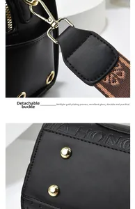 Detail of gold-plated detachable buckle and protective bottom studs on black leather bag