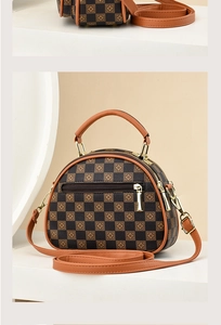 Macro detail of the checkered pattern and brown leather handles on a retro semi-circle bag