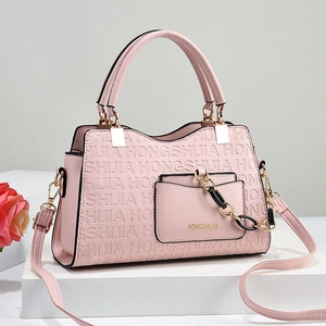 Sac à main rose en cuir gaufré avec bandoulière chaîne et motifs lettrés sur socle