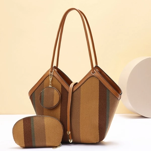Detail of woven striped tote bag with leather handles and matching zipper pouch