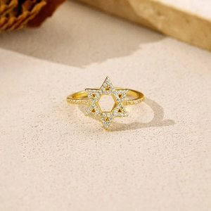 Davidstern-Ring in Gold mit Pavé-Zirkonia auf strukturiertem Stein-Hintergrund