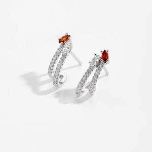 Detail of S925 silver C-shape earrings with marquise-cut orange and clear cubic zirconia