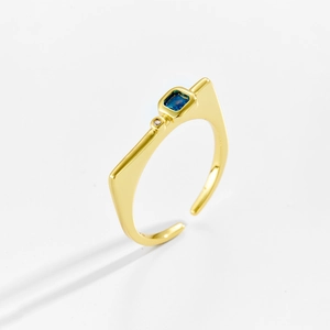 Detail shot of a golden adjustable ring with a square blue zircon and mirror finish