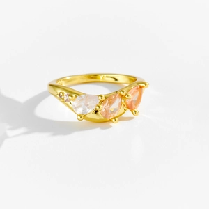Detail of gold ring featuring three pear-cut champagne and clear stones with side zirconias