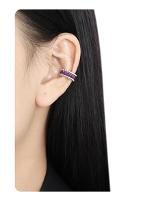 Dettaglio dell'orecchino a triplo strato in argento con gemme viola indossato da una modella