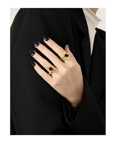 Detail of two irregular gold-plated S925 silver rings with black rectangular stones