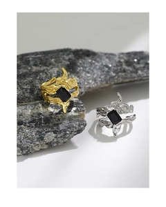 Macro shot of irregular lava texture rings with rectangular black zircon in gold and silver