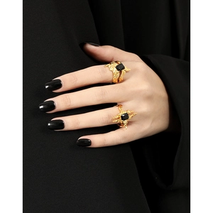 Minimalist irregular gold ring set with black square zircon stones on model's hand
