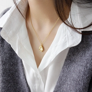 Collar de plata S925 dorada con colgante de textura de roca usado en el cuello de mujer