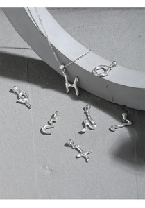 Detailed macro view of S925 sterling silver irregular alphabet charms on a stone surface