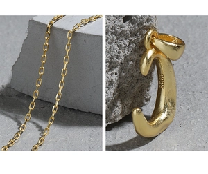 Macro detail of gold S925 sterling silver letter C pendant with hammered texture and chain